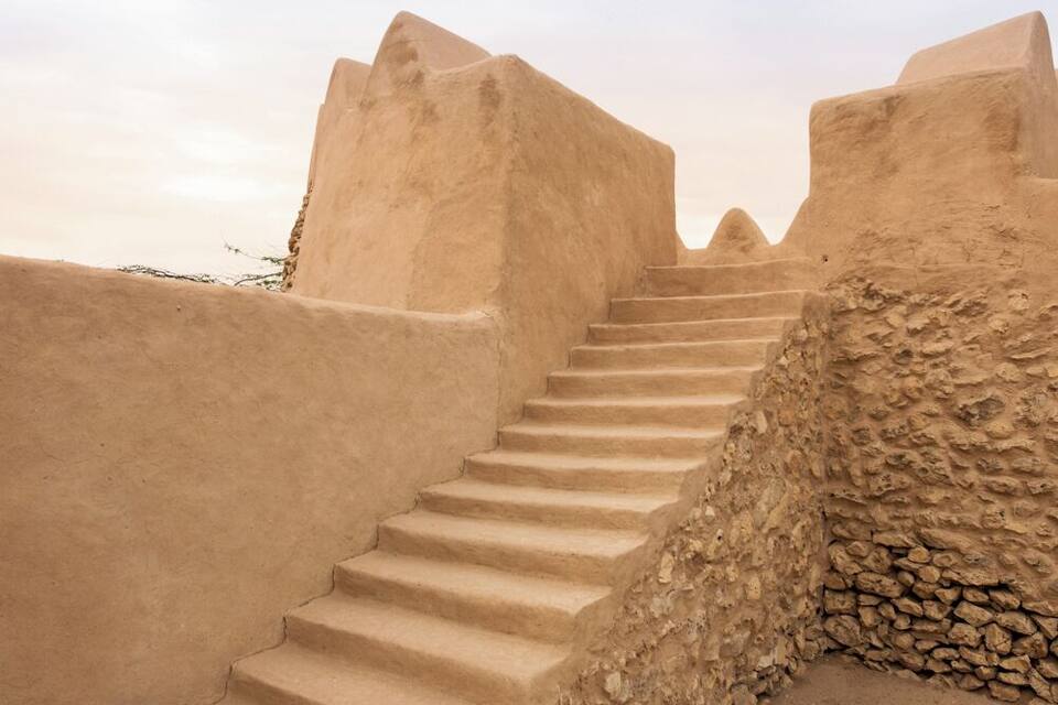 Un conjunt d'escales de pedra que s'eleven cap a un turó, envoltades per murs de terra.