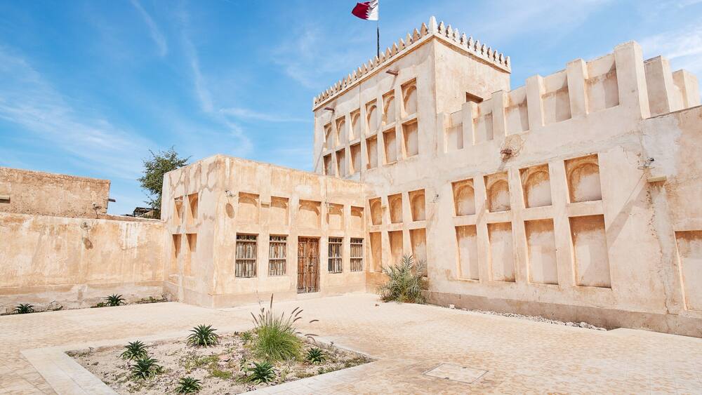 Ein historisches Gebäude mit Bogenfenstern und einer Fahnenstange.