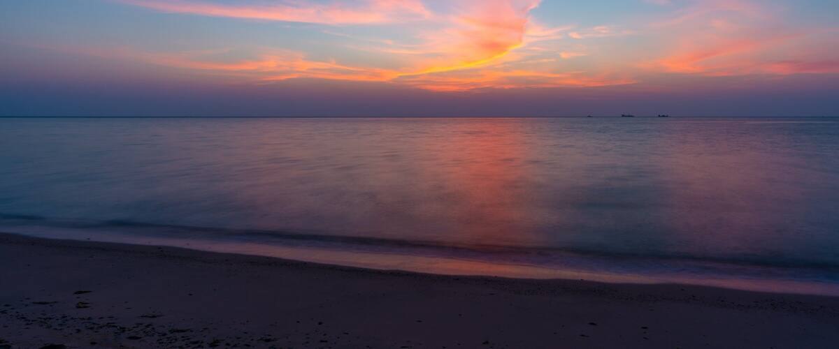 Al Wakrah Beach which includes a beach, a sunset and general coastal views