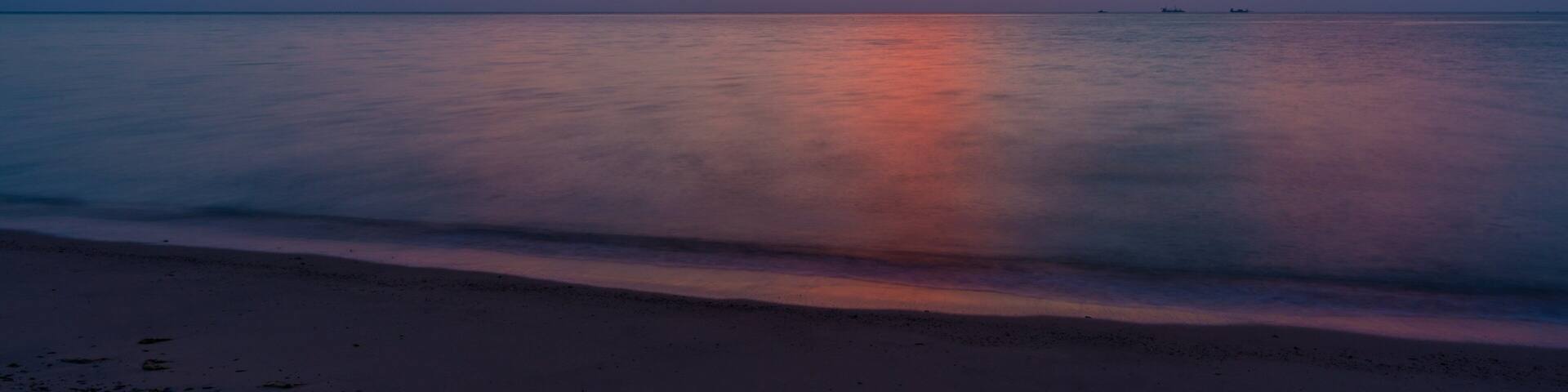 Al Wakrah Beach which includes a beach, a sunset and general coastal views