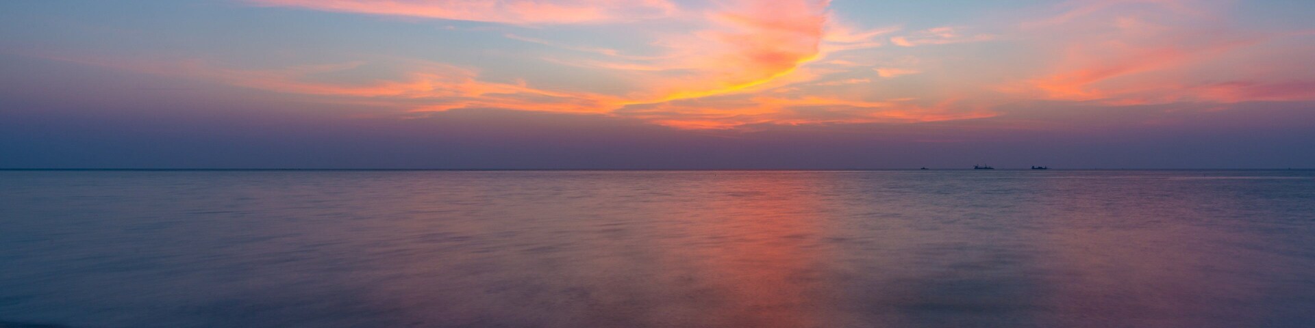 Al Wakrah Beach which includes a beach, a sunset and general coastal views