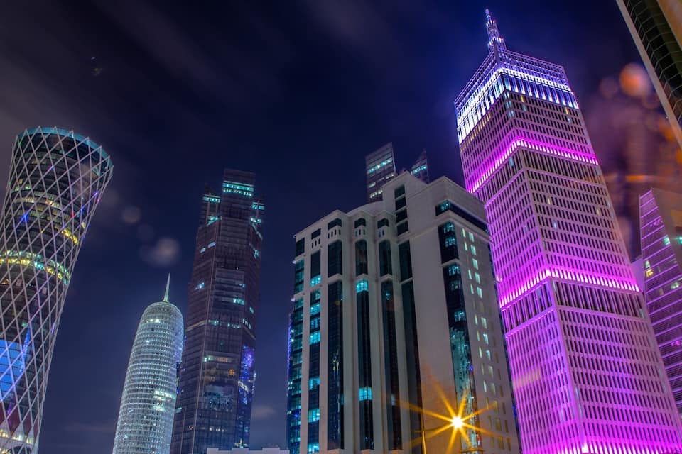 A cityscape at night with illuminated skyscrapers.
