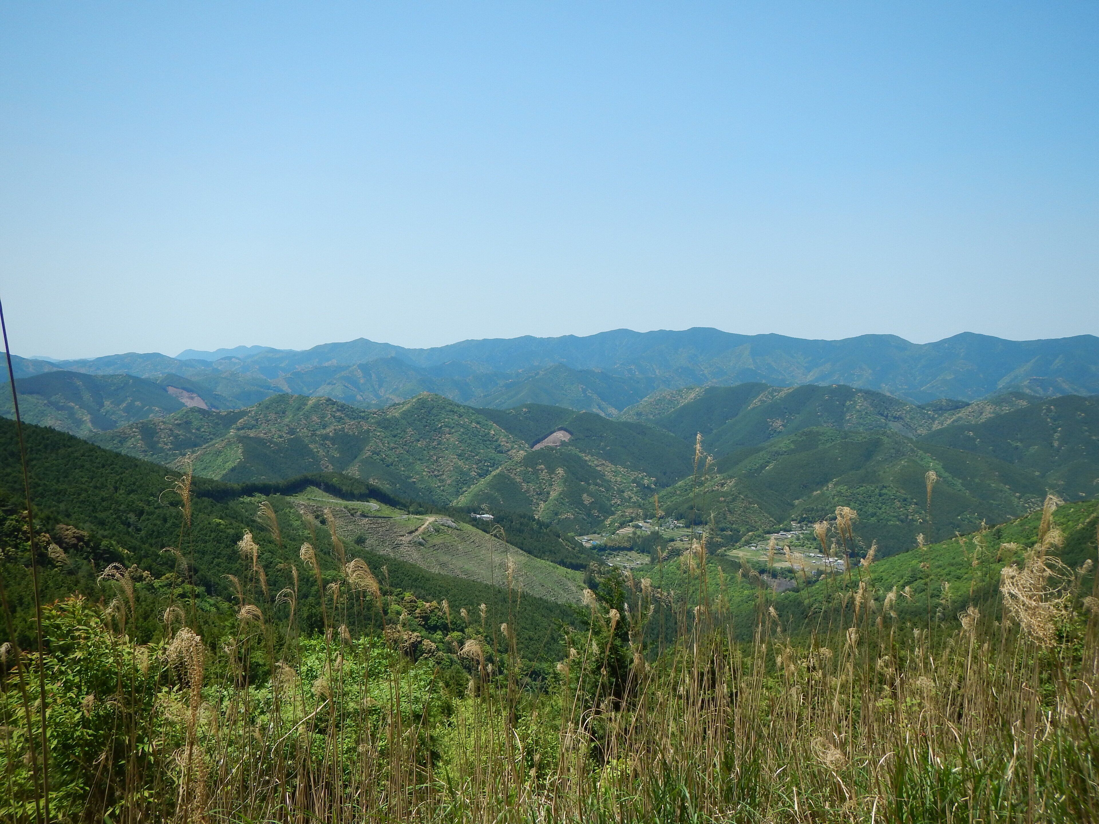 A mountainous landscape with rolling hills and scattered vegetation.