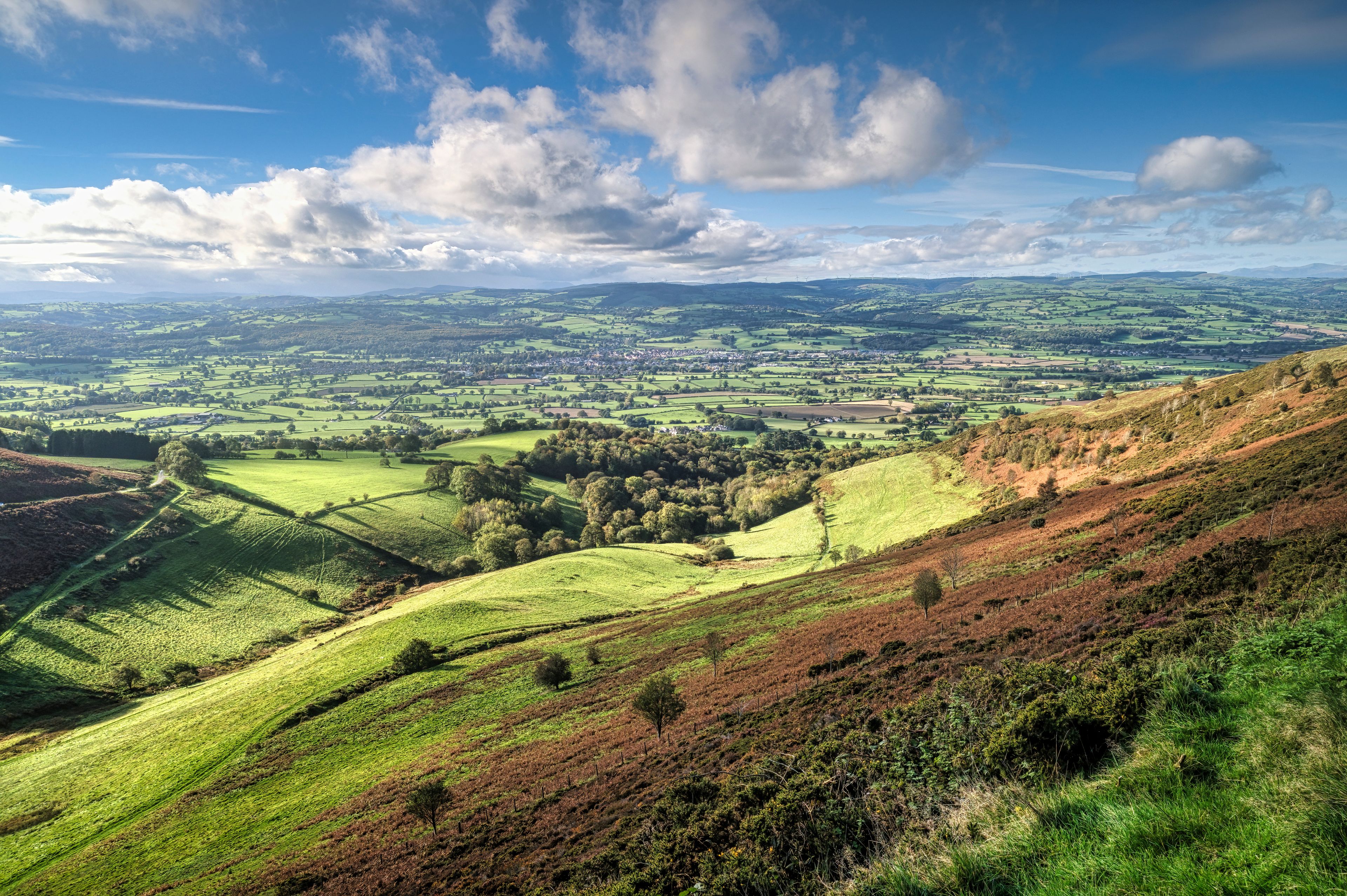 Rolling hills, a valley, and a distant town.