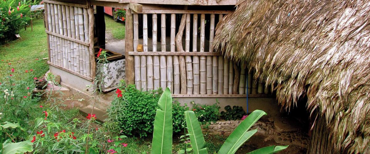 A thatched-roof house with a wooden balcony.