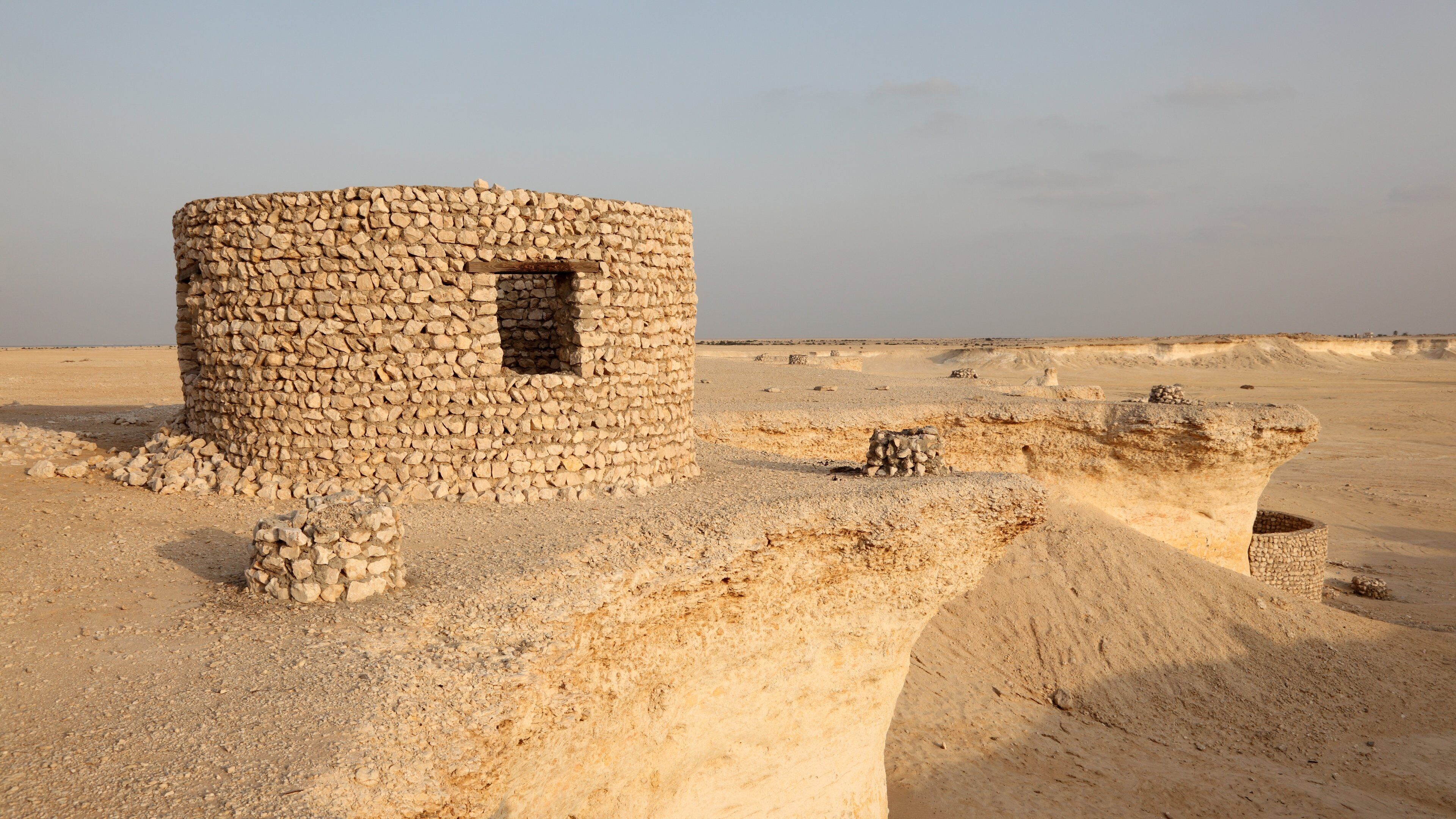 A stone structure in a desert landscape.