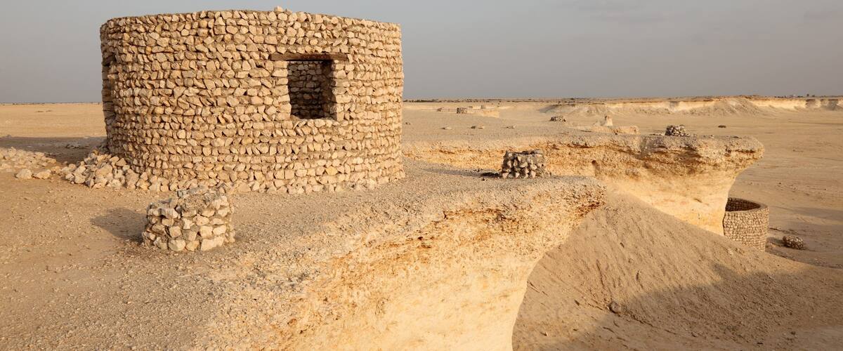 A stone structure in a desert landscape.