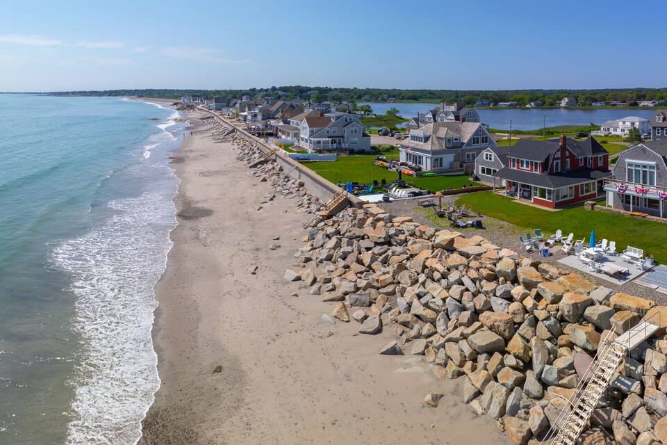 A coastal town with a rocky shoreline, houses, and a body of water.