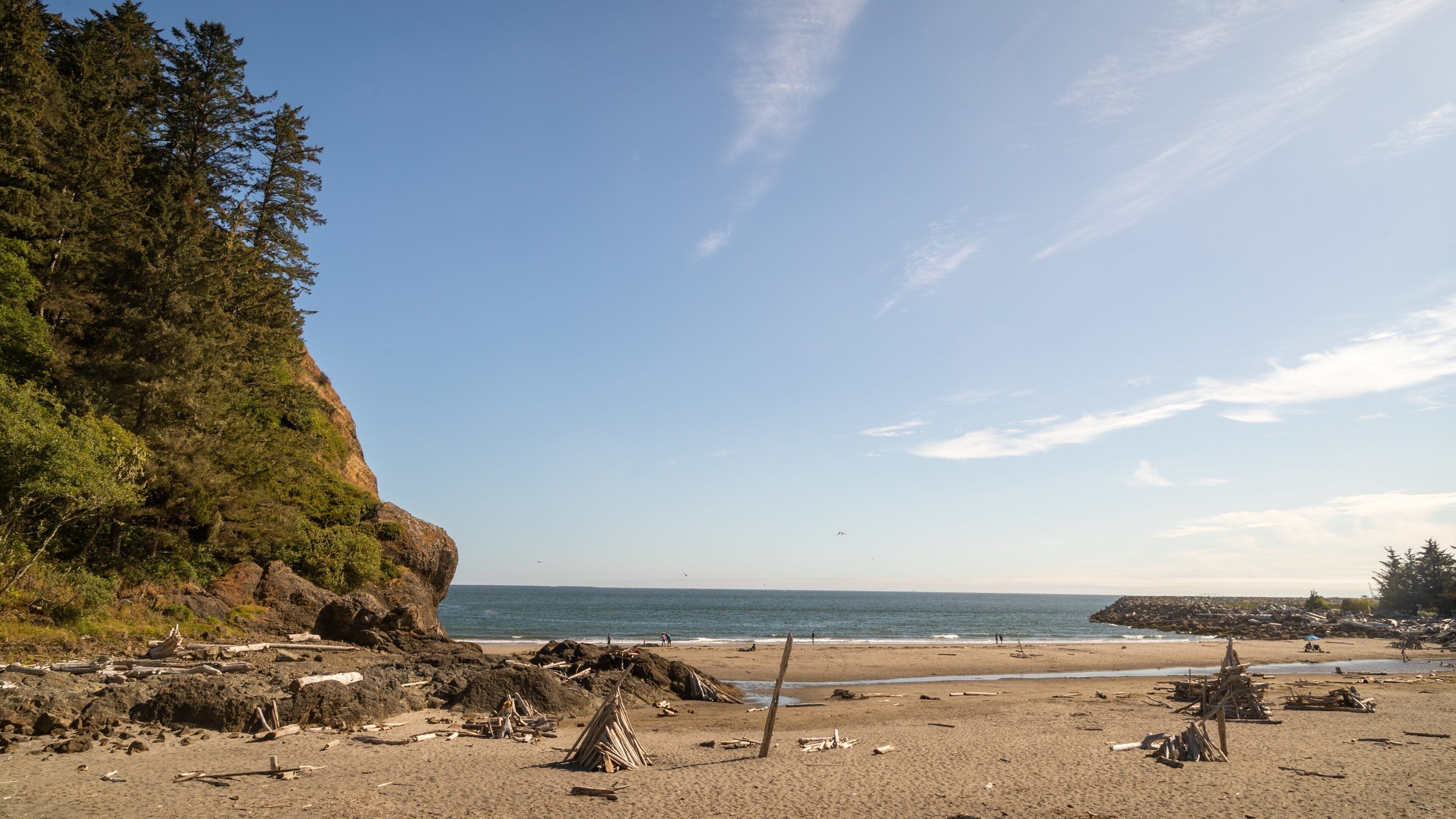 A beach with rocky terrain, a cliff, and the ocean.