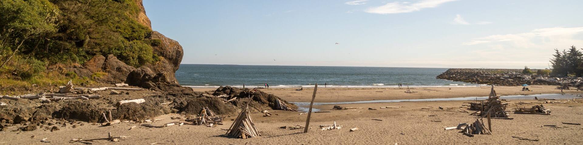 Una playa con terreno rocoso, un acantilado y el océano.