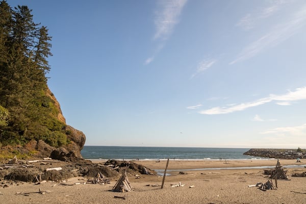 A beach with rocky terrain, a cliff, and the ocean.