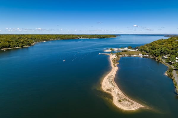 Aerial view over a large sandbar in the green waters of Oyster Bay in Lloyd Harbor on Long Island