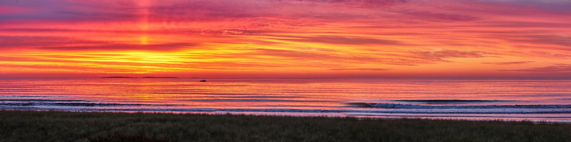 Panorama of Maine east coast beach during beautiful sunrise with golden light