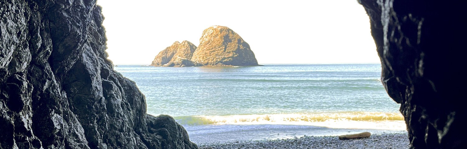 Tunnel Beach cave opening with Oregon Coast rocks in the distance with natural framing