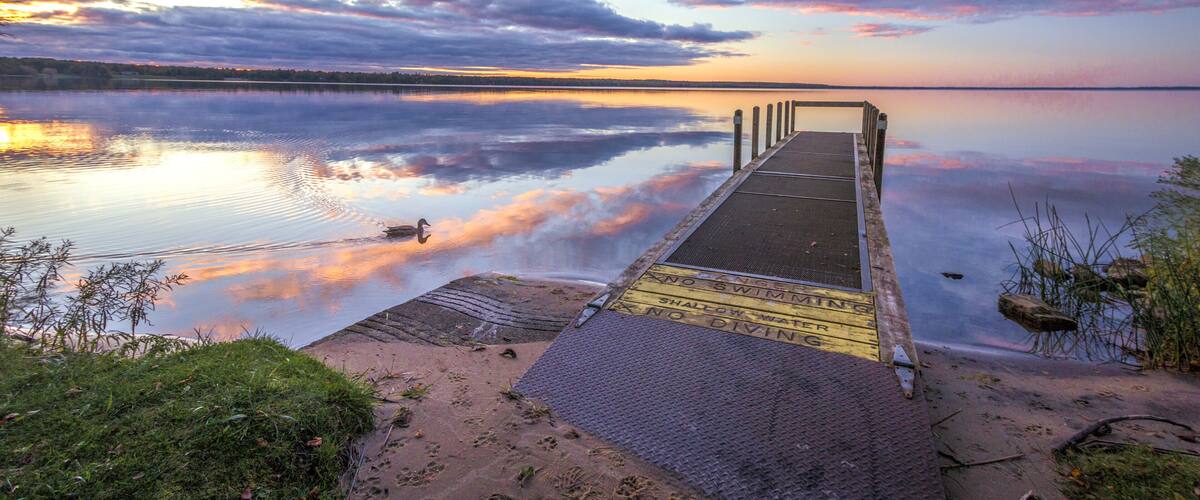 Summer At The Lake. Beautiful sunset reflected in the clean waters of Indian Lake State Park in the Upper Peninsula of Michigan.