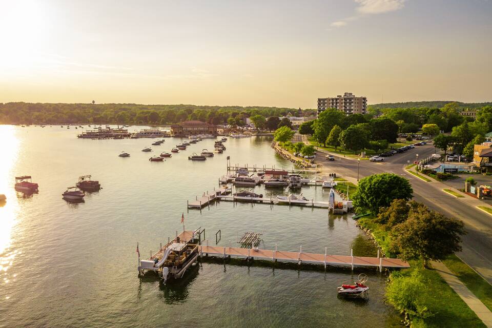 A marina with boats docked, a bridge, and a cityscape with buildings in the background.