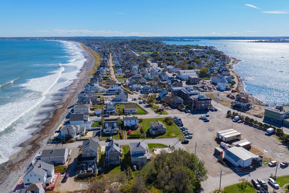 A coastal residential area with houses along the beach and a marina.