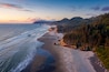 Aerial View of Arch Cape, Oregon. Sunset along the Oregon coast near Cannon Beach features white sand beaches with fir and cedar forests as far as the eye can see.