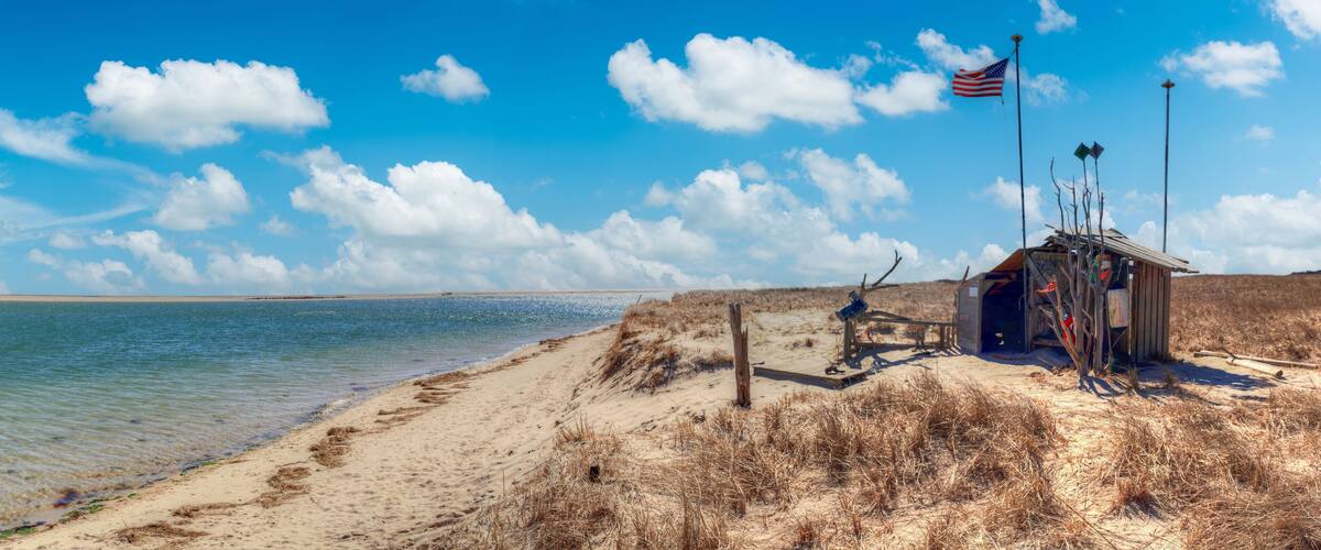Fluffy clouds and blue sky over the Occupy Chatham public shack on Chatham South Beach