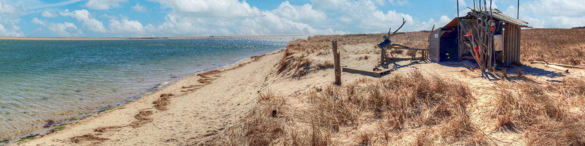 Fluffy clouds and blue sky over the Occupy Chatham public shack on Chatham South Beach
