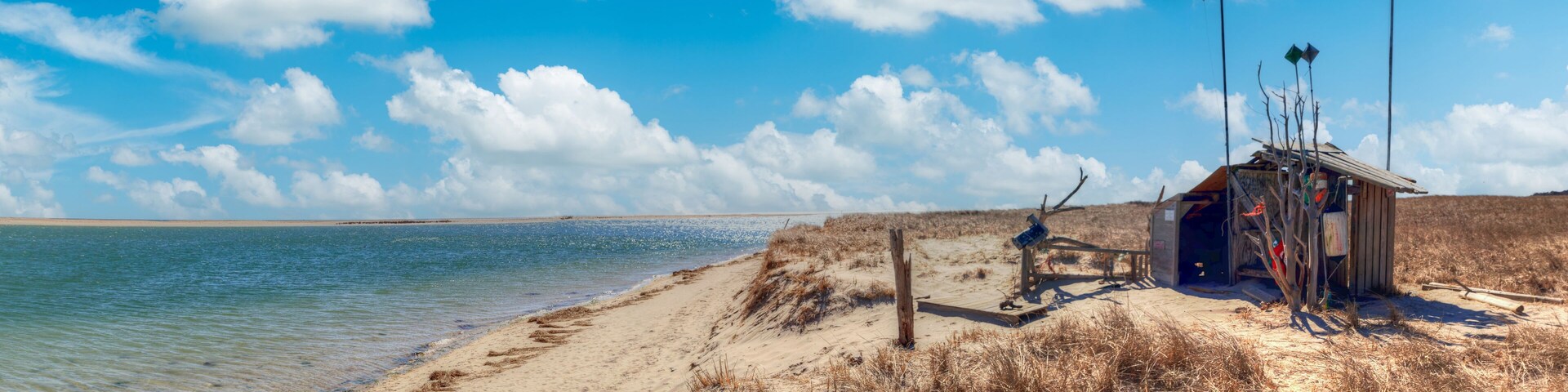Fluffy clouds and blue sky over the Occupy Chatham public shack on Chatham South Beach