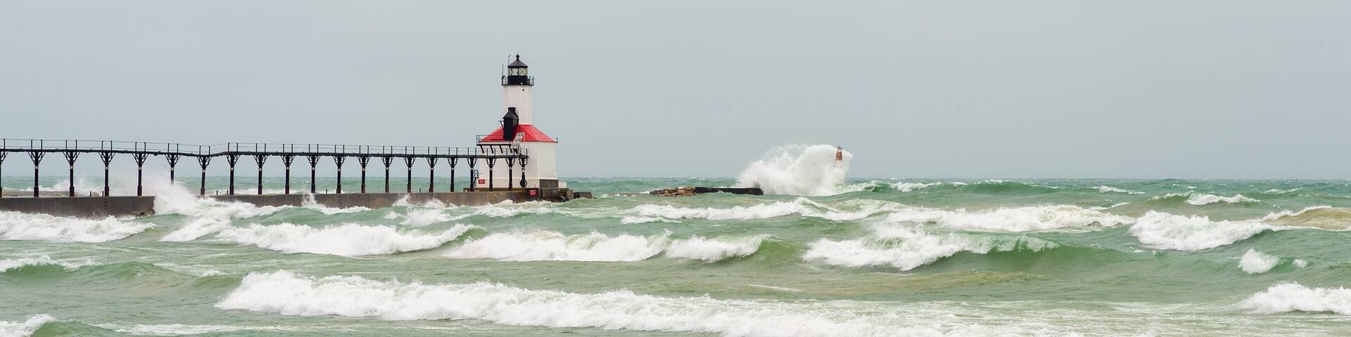 Lake Michigan waves crash against the East Pierhead Outer Lighthouse and catwalk, in Michigan City, Indiana.