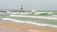 Lake Michigan waves crash against the East Pierhead Outer Lighthouse and catwalk, in Michigan City, Indiana.