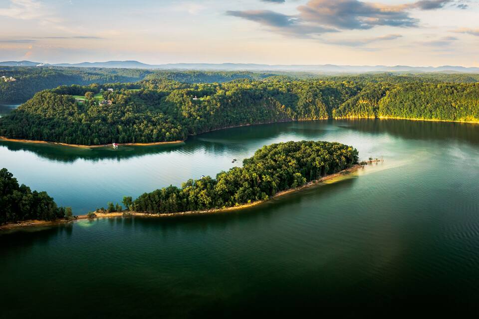 A lake surrounded by dense forest and hills.
