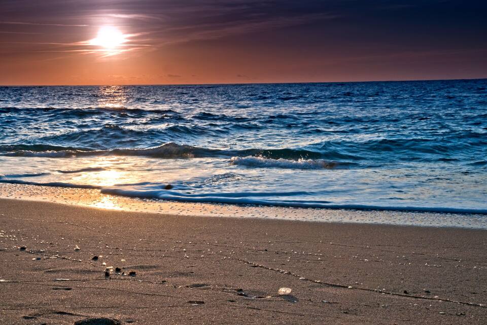 Una platja amb ones i un capvespre.
