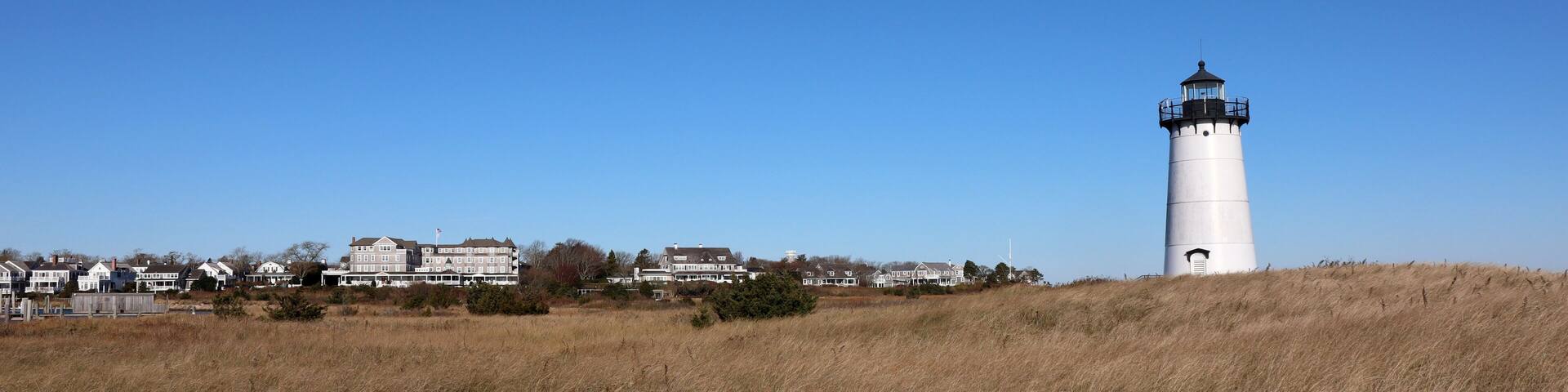 Edgartown lighthouse with a view of the city in the background and blue sky