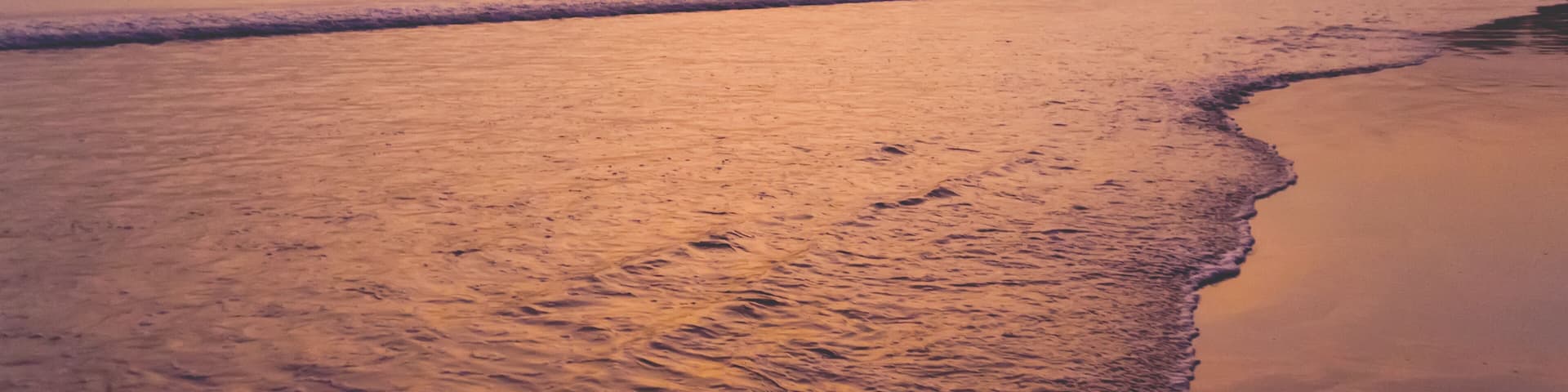 The sun sets on the final days of summer over a beach