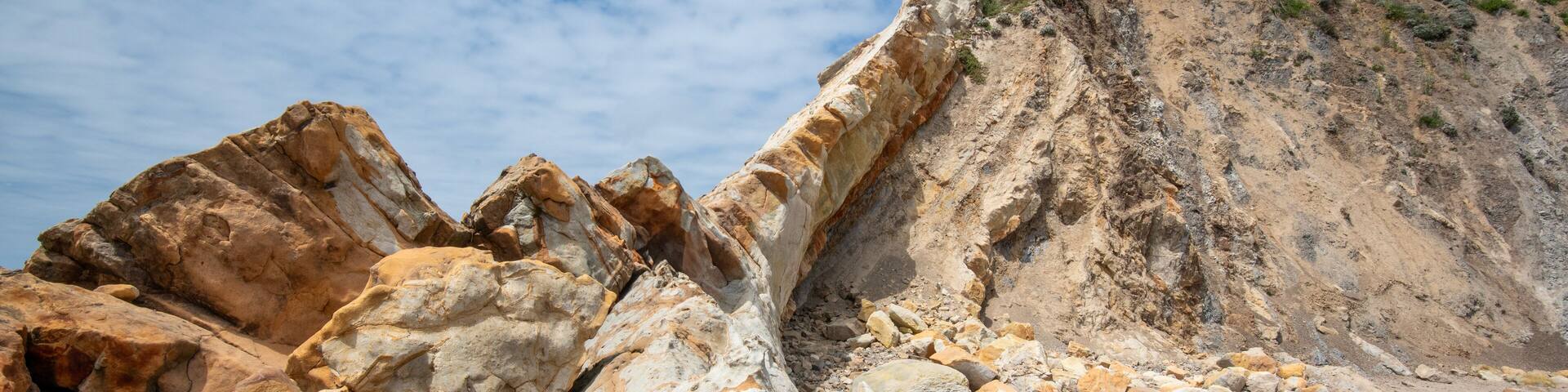 Sandstone ledge at Cooks Beach, Gualala, California, USA, on a cloudly day, featuig orange and tan tones