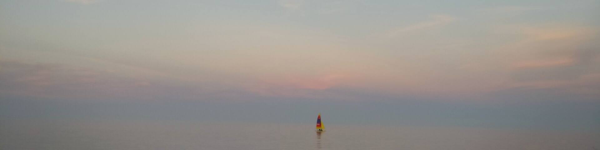 This beach is in Centennial Park in Evanston, IL
This picture was taken at sunset which was happening on the opposite side but I'm facing east here and you can see the sunset reflection on the horizon. It was perfect timing because water was very calm and it was hard to tell were skies connect with water on the horizon.