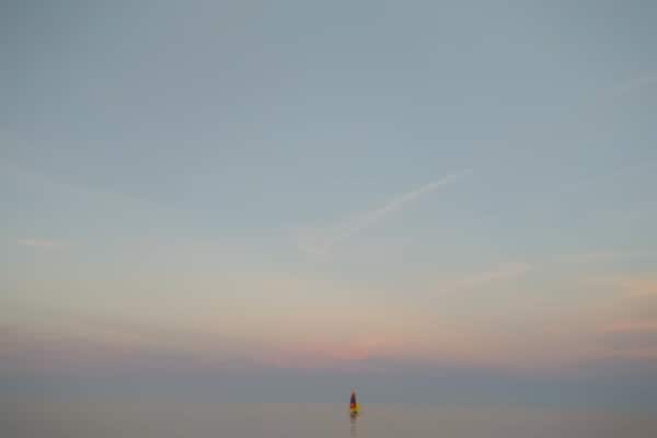 This beach is in Centennial Park in Evanston, IL
This picture was taken at sunset which was happening on the opposite side but I'm facing east here and you can see the sunset reflection on the horizon. It was perfect timing because water was very calm and it was hard to tell were skies connect with water on the horizon.