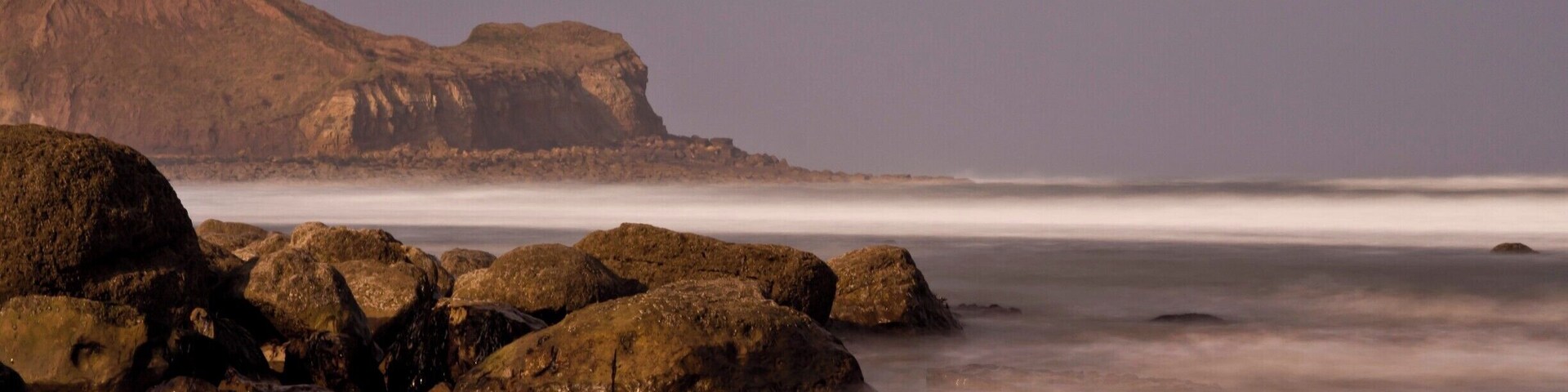 Down on the beach at Cayton Bay just south of Scarborough North Yorkshire (UK) behind the large outcrop is Scarborough..The tide was just rolling on as the photograph was taken..a great place to walk along the wide open beach.