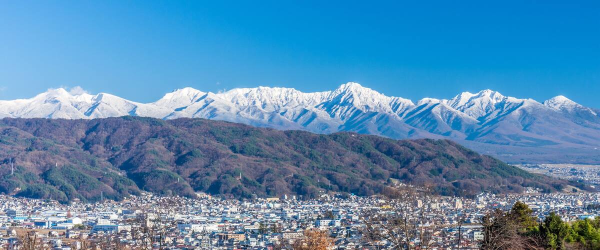 Panorama cityscapoe and mountain landscape view of Suwa city. The city is on the shore of Lake Suwa, in central Nagano Prefecture, Japan.