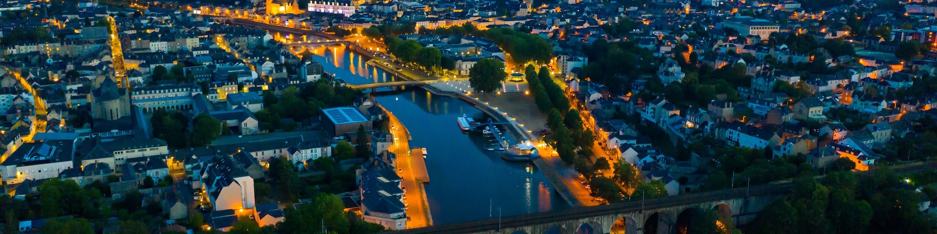 Evening aerial view of Laval with buildings, river Mayenne and old bridge, Mayenne department, north-western France