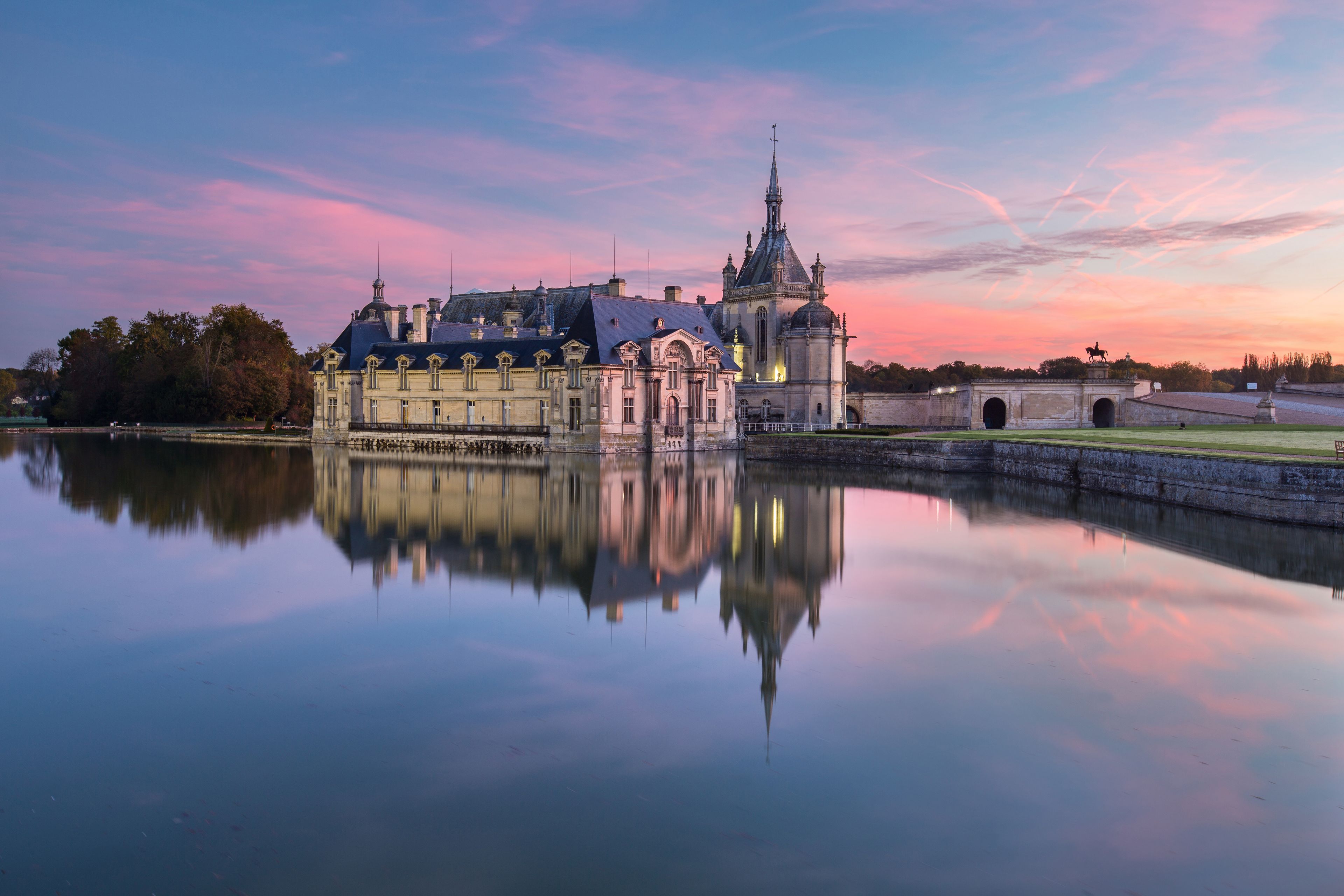Un bâtiment historique doté d’une grande tour et dont l’image se reflète dans l’eau.
