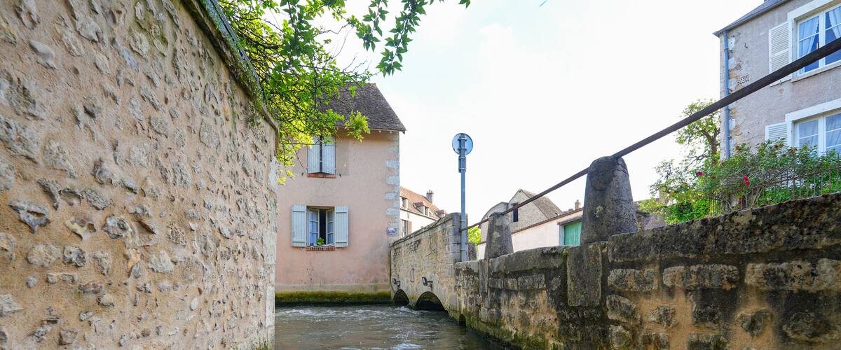 River La Cléry flowing at the foot of the houses of Ferrière-en-Gâtinais in the French department of Loiret, Centre Val de Loire, France