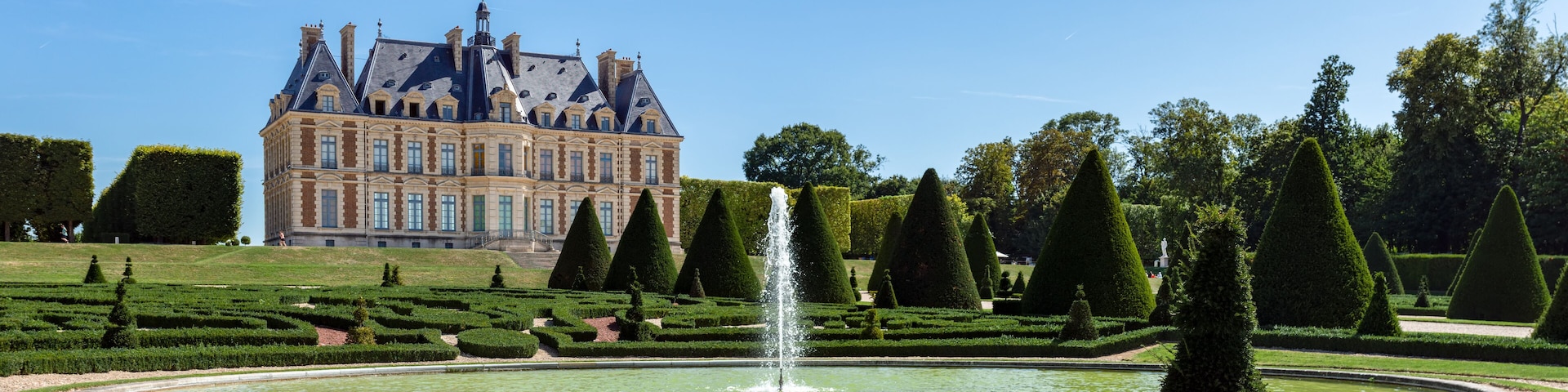 Panoramic view of Parc and chateau de Sceaux with a fountain in foreground - Hauts-de-Seine, France.