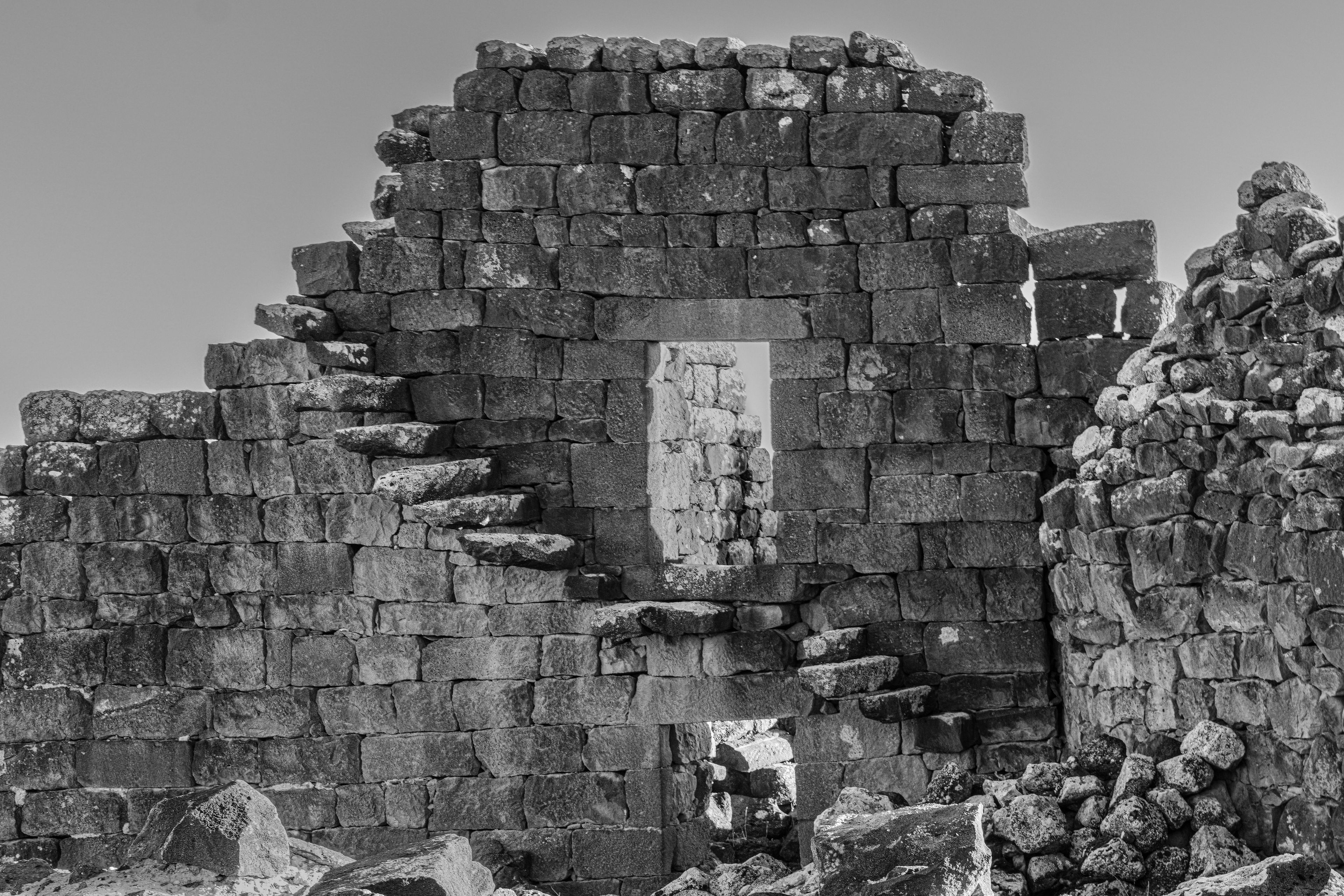 A stone wall with a rectangular opening, surrounded by uneven stone blocks.