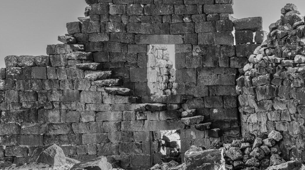 A stone wall with a rectangular opening, surrounded by uneven stone blocks.