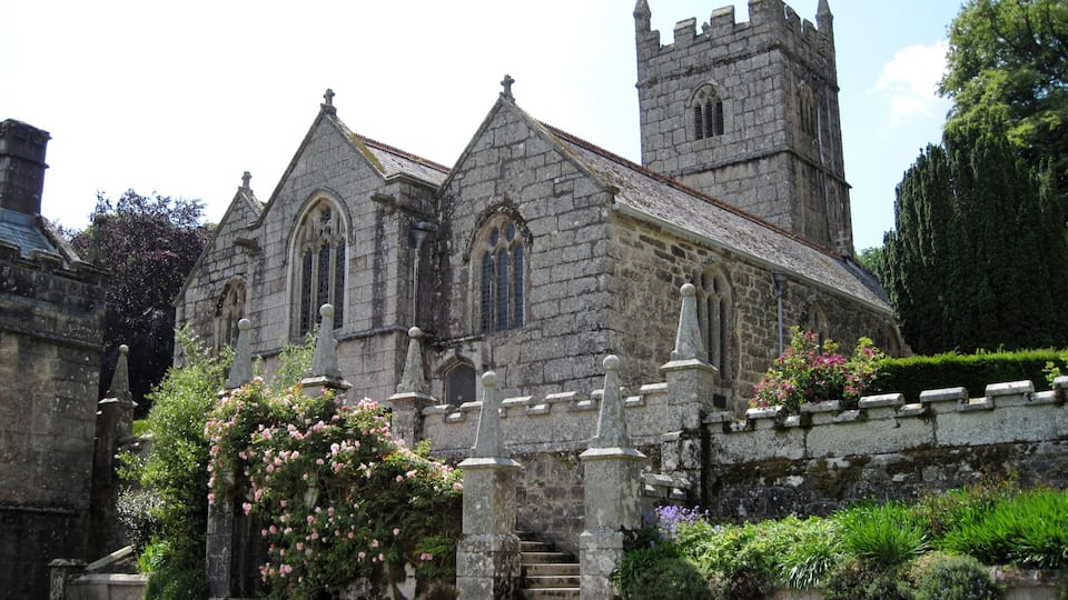 A historic stone church with a tall tower and arched windows.