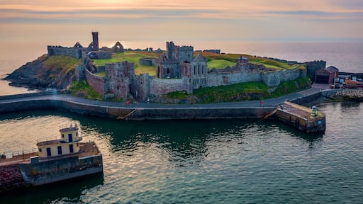 A historic coastal fortification with ruins and a lighthouse.