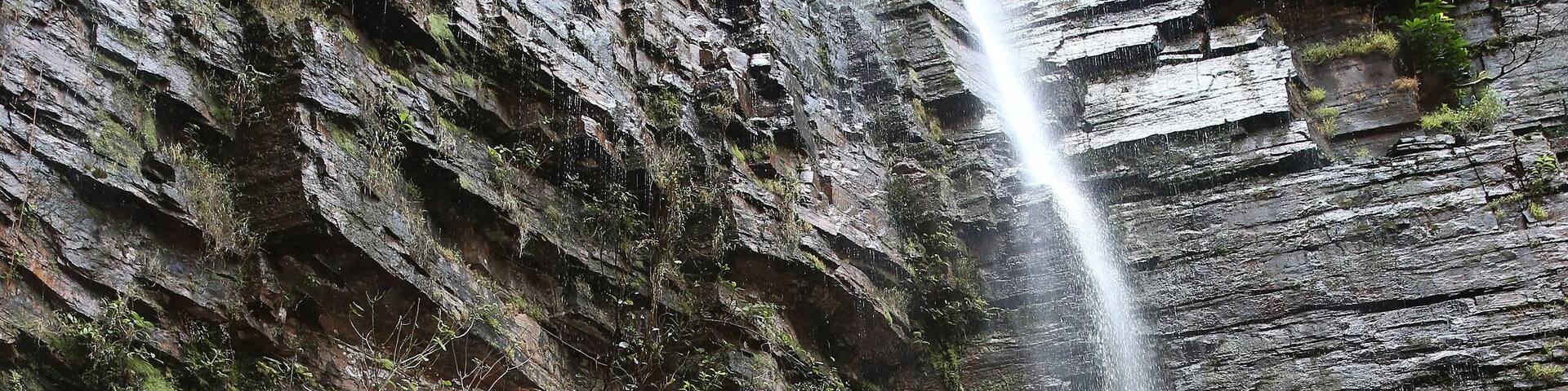 Dindefelo waterfall and tourist people, woman with child, kid. Kedougou, Senegal, Africa. Senegalese landmark, african scenic landscape, Kedougou scenery. Beautiful Dindefelo waterfall. Big waterfall