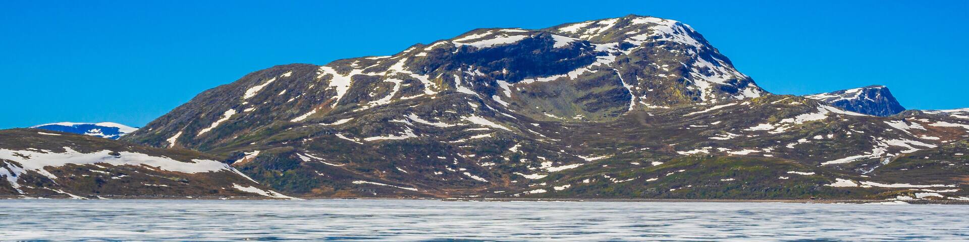 Frozen turquoise lake Vavatn panorama in summer landscape Hemsedal Norway.