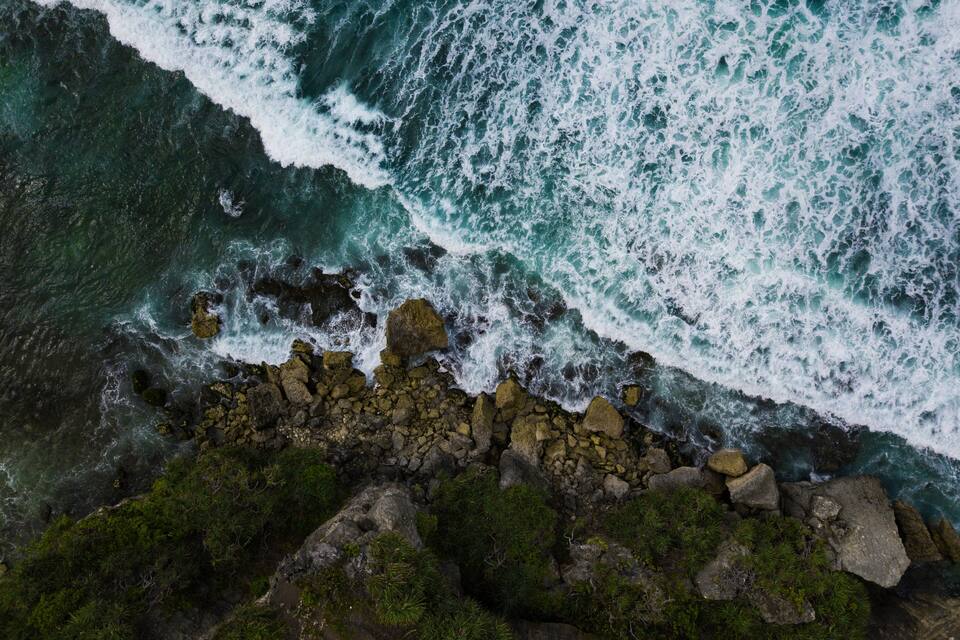 A rocky coastline with waves crashing against the shore.