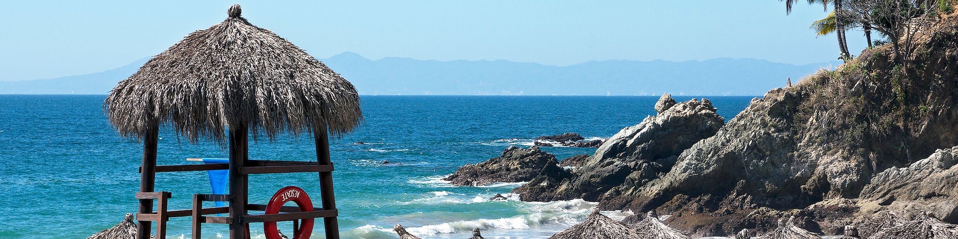 Palapas and guard tower on Playa las Estacas in Puerto Vallarta, Mexico