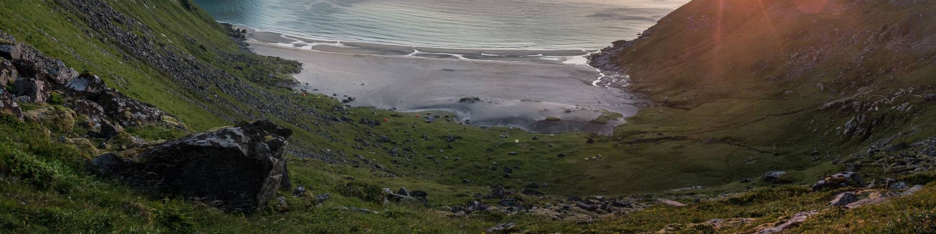 A coastal landscape with cliffs, a bay, and a sunset.