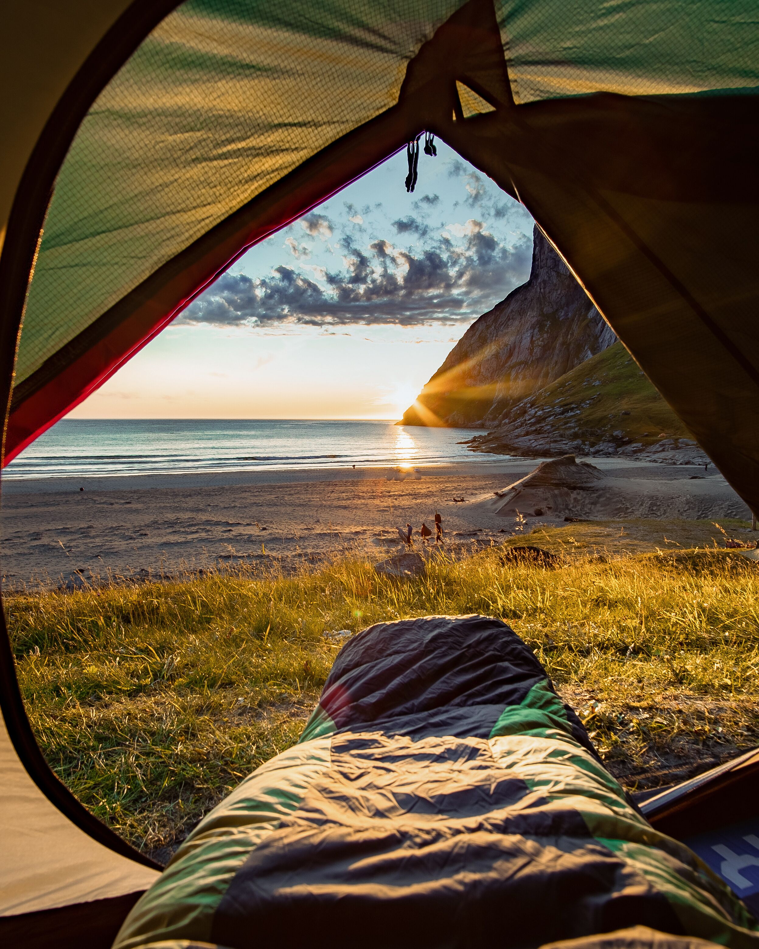 Camping on the Beach at Sunset. Spectacular sunset view to rugged mountain peaks above Kvalvika - famous surfing beach at Lofoten islands, Norway. Lifestyle summer journey vacations